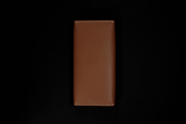 Brown full-grain leather wallet on dark background, practical gift for dad